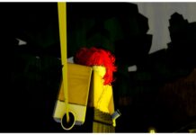 Onikami Slayer Marks Guide Feature image for our Onikami Slayers Marks guide showing a front facing image of my avatar who has bright red hair and her blade held facing the camera in a more of a resting position as yellow light illuminates the right side of her body