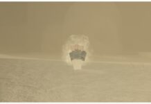Roblox Sorcery Simple Domain – How To Obtain and What It Does! Feature image for our Roblox Sorcery Simple Domain guide showing my red-haired character in the violent sandy dunes in greyscale with a white wispy aura coating her body